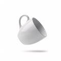 An empty white ceramic mug flying through the air at an angle, casting a shadow Royalty Free Stock Photo