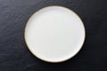 Empty white ceramic plates with spoons and forks arranged on an old black wooden table - top view Royalty Free Stock Photo