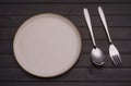 Empty white ceramic plates with spoons and forks arranged on an old black wooden table - top view Royalty Free Stock Photo