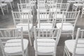 Empty white chairs for guests at a banquet or wedding on an outdoor summer area are in a row. Royalty Free Stock Photo