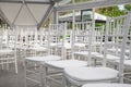 Empty white chairs for guests at a banquet or wedding on an outdoor summer area are in a row. Royalty Free Stock Photo