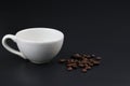 Empty white coffee cup with coffee bean on black color background. Royalty Free Stock Photo