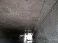 The empty white concrete square tunnel outside. Exit from bunker with light in the end. Inside empty concrete tubing tunnel.