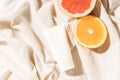 Empty white cream tube mockup unbranded and citrus slices lying on a cotton cloth