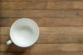 Empty white cup for tea or coffee on wooden table. Copy space. Flat lay. Top view. Unfilled mug