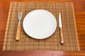 Empty white dish and cutlery set on bamboo table mat Royalty Free Stock Photo