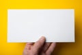 Empty white DL Flyer in hand on yellow background. Mockup, horizontal