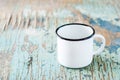 Empty white enameled mug on an old wooden table. Dishes for camping and travel. Copy space Royalty Free Stock Photo