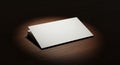 An empty, white envelope is placed on a dark wooden surface, illuminated with focuse Royalty Free Stock Photo