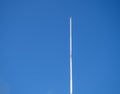 Empty white flagpole against the blue sky. Lowered flag Royalty Free Stock Photo