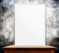 Empty white frame on wooden table at grunge concrete wall in background,Mock up for adding your design, Royalty Free Stock Photo