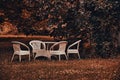 Empty and white garden table and chairs in a garden in autumn. Royalty Free Stock Photo