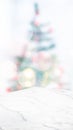 Empty white marble table top with abstract Christmas tree decor string light blur background,Holiday backdrop,Mockup vertical Royalty Free Stock Photo