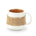 Empty white matte cup with brown interior wrapped in burlap with fringe. Isolated on white background with soft shadow