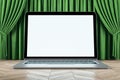 Empty white mock up laptop monitor, green curtains and wooden flooring. Cinema, stage and theater.