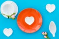 Empty white and orange colorful plate and rose for table setting on blue table backgroung top view Royalty Free Stock Photo