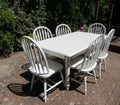 Empty white outdoor patio chairs and table in garden