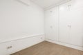 Empty white painted room with reddish marble floors and fitted wardrobes Royalty Free Stock Photo