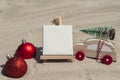 Empty white paper note frame with copy space for your text or design displays on sandy beach. Christmas balls car with Royalty Free Stock Photo