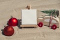 Empty white paper note frame with copy space for your text or design displays on sandy beach. Christmas balls car with Royalty Free Stock Photo