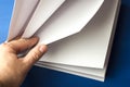 Empty white paper for notes, notebook, diary, booklet, organizer in hand on a blue background. Royalty Free Stock Photo