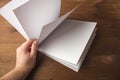 Empty white paper for notes, notebook, diary, booklet, organizer in hand on a wooden table. Royalty Free Stock Photo