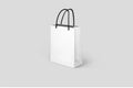 Empty white paper shopping bag isolated on grey background. Royalty Free Stock Photo