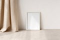 Empty white picture frame mockup on neutral beige table and wall background, linen curtains and soft sunlight shadow Royalty Free Stock Photo