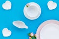 Empty white and pink colorful plate and rose for table setting on blue table backgroung top view Royalty Free Stock Photo