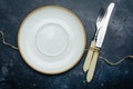 Empty white plate ceramic, rustic on a dark blue background with a knife and fork. Royalty Free Stock Photo