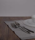 Empty white plate and cutlery, table setting on the wooden table, flat lay