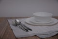 Empty white plate and cutlery, table setting on the wooden table, flat lay