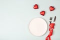 Empty white plate and cutlery. Valentine`s Day theme. Place for text