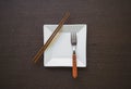 Empty white plate with fork and chopsticks wooden table Royalty Free Stock Photo