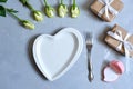 empty white plate with hearts on Ultimate Gray background with white roses and fork. The moment of a wedding anniversary