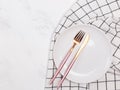 Empty white plate and modern design cutlery on the white marble table Royalty Free Stock Photo