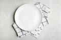 Empty white plate and napkin on grey marble table, flat lay Royalty Free Stock Photo