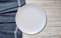 Empty white plate and napkin on light grey table, flat lay Royalty Free Stock Photo