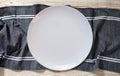 Empty white plate and napkin on light grey table, flat lay Royalty Free Stock Photo