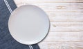 Empty white plate and napkin on light grey table, flat lay Royalty Free Stock Photo