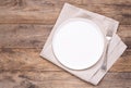 Empty white plate with napkin and silver fork on old wooden table Royalty Free Stock Photo