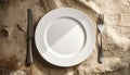 Empty White Plate With Silverware on Textured Fabric Surface dinner plate empty plate Royalty Free Stock Photo