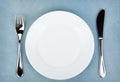 Empty white plate with silverware on wooden table Royalty Free Stock Photo