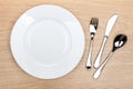 Empty white plate with silverware on wooden table Royalty Free Stock Photo