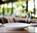 Empty white plate on table with wine glasses and empty place settings, AI Royalty Free Stock Photo