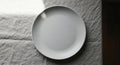Empty White Plate on a Textured Gray Fabric Surface Royalty Free Stock Photo