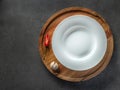 Empty white plate on wooden plate and black background with red pepper and garlic Royalty Free Stock Photo