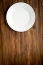 Empty white plate on wooden table