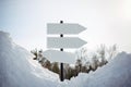 Empty white pointers, guidepost against winter nature background. Directional arrow signs on pole in snowy forest. Christmas and Royalty Free Stock Photo