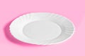 Empty white porcelain plate on a trendy pink background. Ready-made template Royalty Free Stock Photo